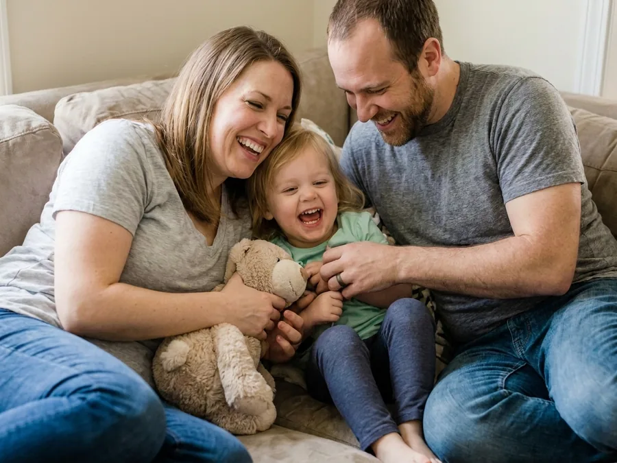 Parents playing with their child on a couch