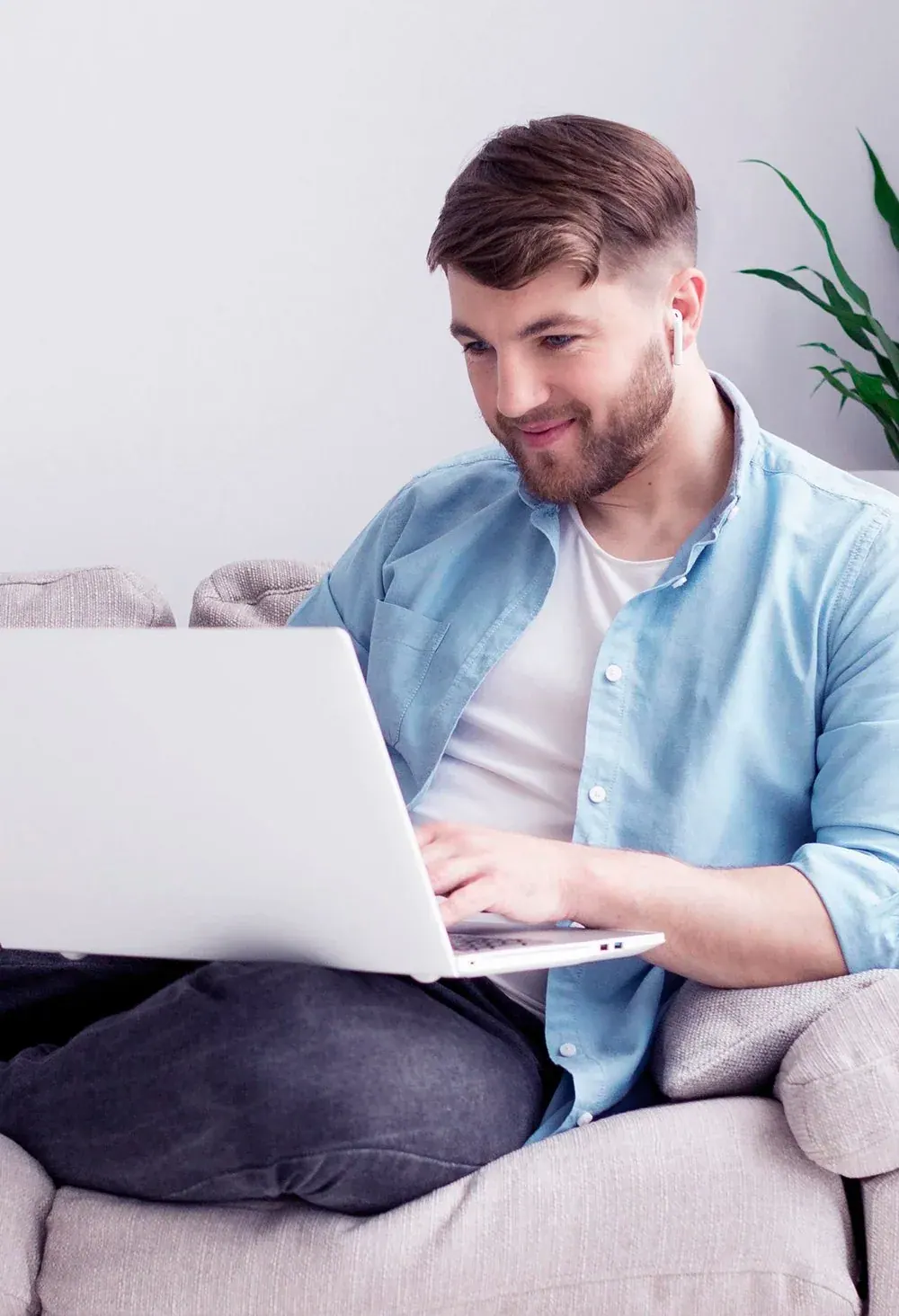 A man on his couch reviewing his sleep test results on a laptop
